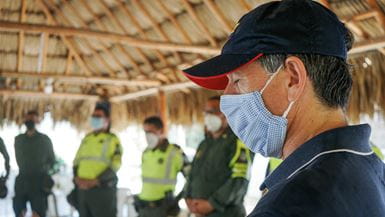 Um homem em uma reunião de oração na Colômbia, com os olhos fechados ao orar antes de entregar alimentos a famílias vulneráveis ​​durante a crise de Covid-19
