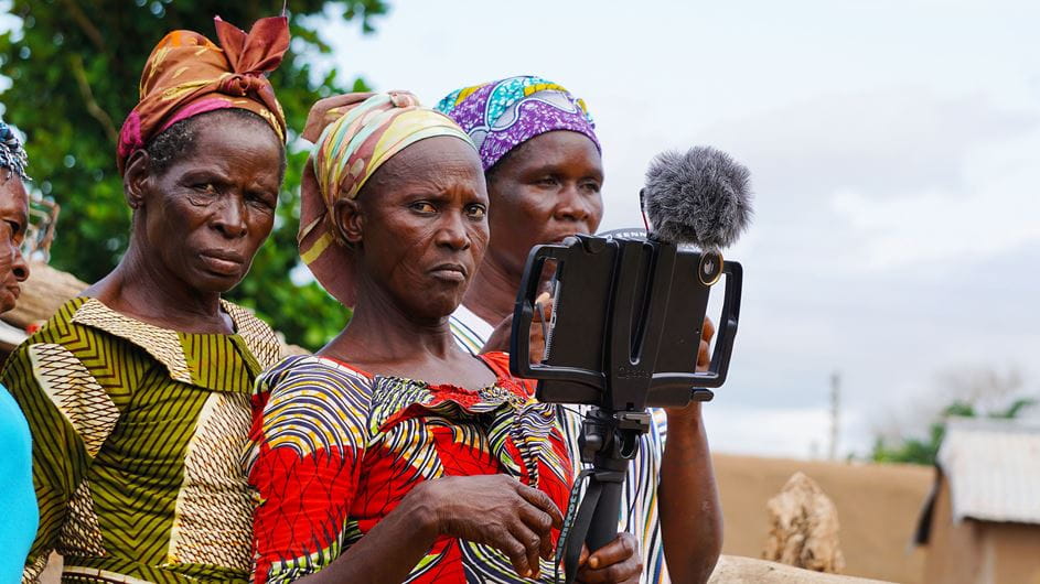 Duas mulheres na zona rural de Gana segurando uma câmera e um microfone