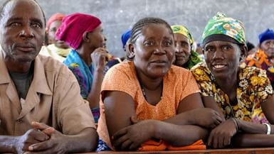 A close-up view of a man and two women in a church in Tanzania