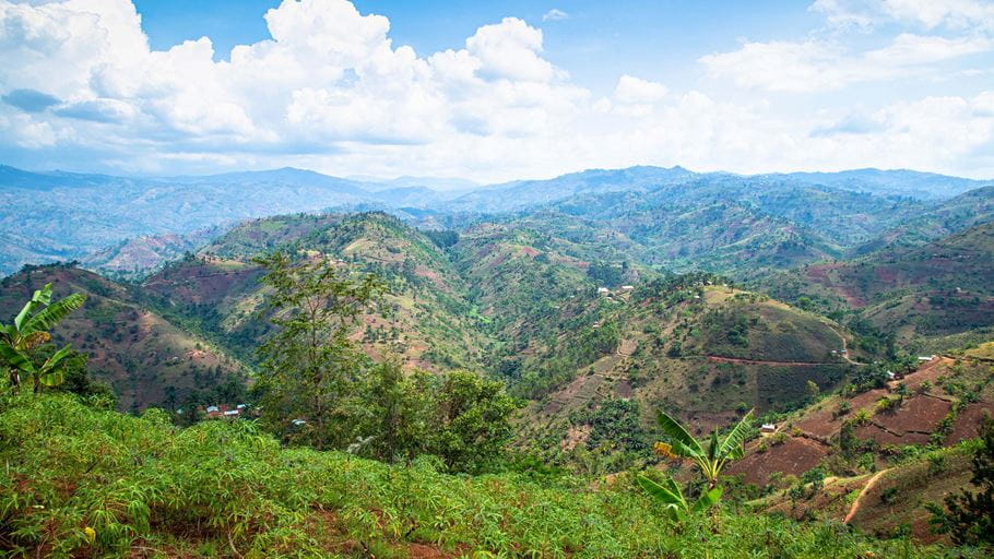 Montanhas e um vale em Kimate, no Burundi, com plantas e árvores verdes