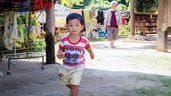 Un jeune garçon, une pomme à la main, court dans son quartier de la province de Chiang Mai, en Thaïlande.