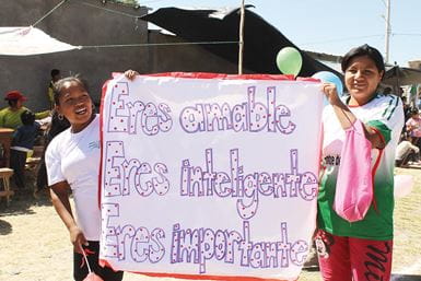 Girls taking part in an awareness-raising campaign aimed at reducing SGBV. The sign says, ‘You are kind, you are intelligent, you are important.’ Photo: Paz y Esperanza