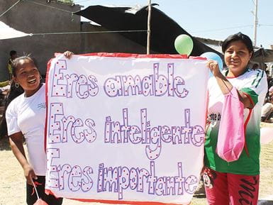 Girls taking part in an awareness-raising campaign aimed at reducing SGBV. The sign says, ‘You are kind, you are intelligent, you are important.’ Photo: Paz y Esperanza
