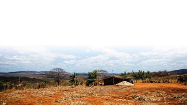 Un village sec et poussiéreux avec plusieurs paillotes dans la campagne brésilienne.