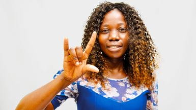 Uma jovem no Zimbábue mostra a língua de sinais do país