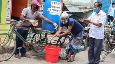 An old man washing his hands at a mobile hand-washing station in Bangladesh