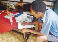 Charles Asso en train de gérer son entreprise.  Photo: Ferdinand Chondy/Yayasan Oikonomos Papua