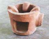 Fuel efficient clay stove promoted by Emmanuel International. The pot sits on the top of the clay stove and the fire sits inside. Photo: Emmanuel International