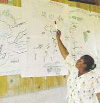 Pensando en la zona local: una mujer presentando su mapa preparado durante el Paso 1 del taller