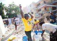 Residentes de Porto Príncipe, no Haiti, trabalhando juntos para limpar os escombros após um grande terremoto em 2010. Foto: Richard Hanson/Tearfund
