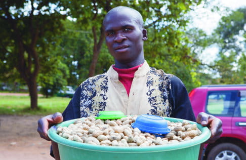 Un agricultor vende cacahuates sanos en Malawi. Foto: Clive Mear/Tearfund