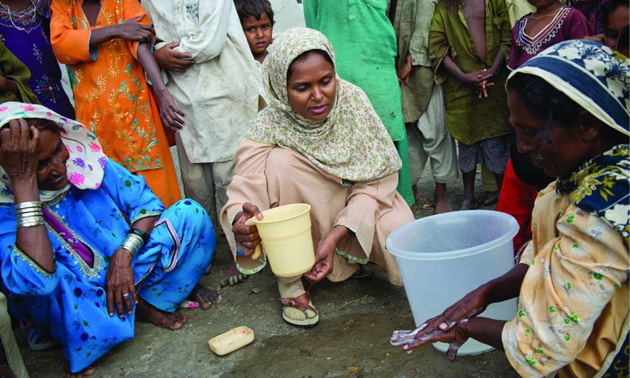 Es importante lavar toda la superficie de las manos con jabón. Rita, una facilitadora de la comunidad (centro) supervisa una demostración de cómo lavarse las manos con jabón en una aldea en UC Jaar, Pakistán. Foto: Richard Hanson/Tearfund