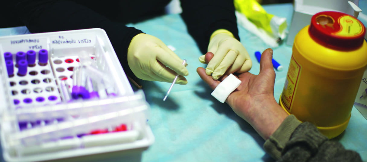 Um agente de saúde realiza um teste de HIV num centro de reabilitação de drogas. Foto: Kieran Dodds/Tearfund