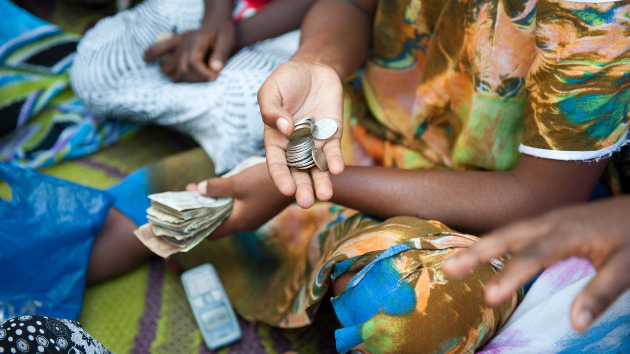 At their weekly self-help group meeting, women deposit savings and issue a loan to a member. 