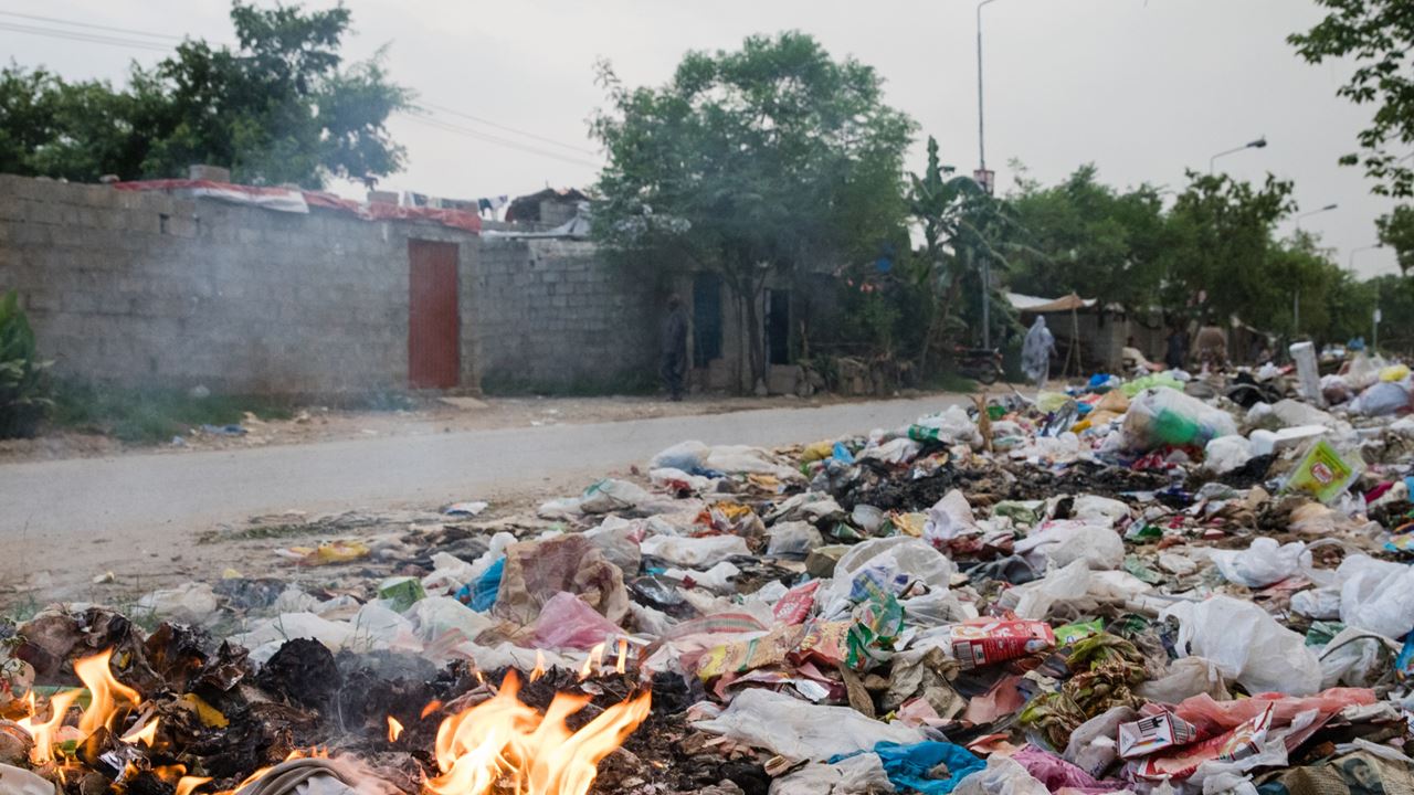 Rubbish burning on the side of the road in an informal settlement in Pakistan.