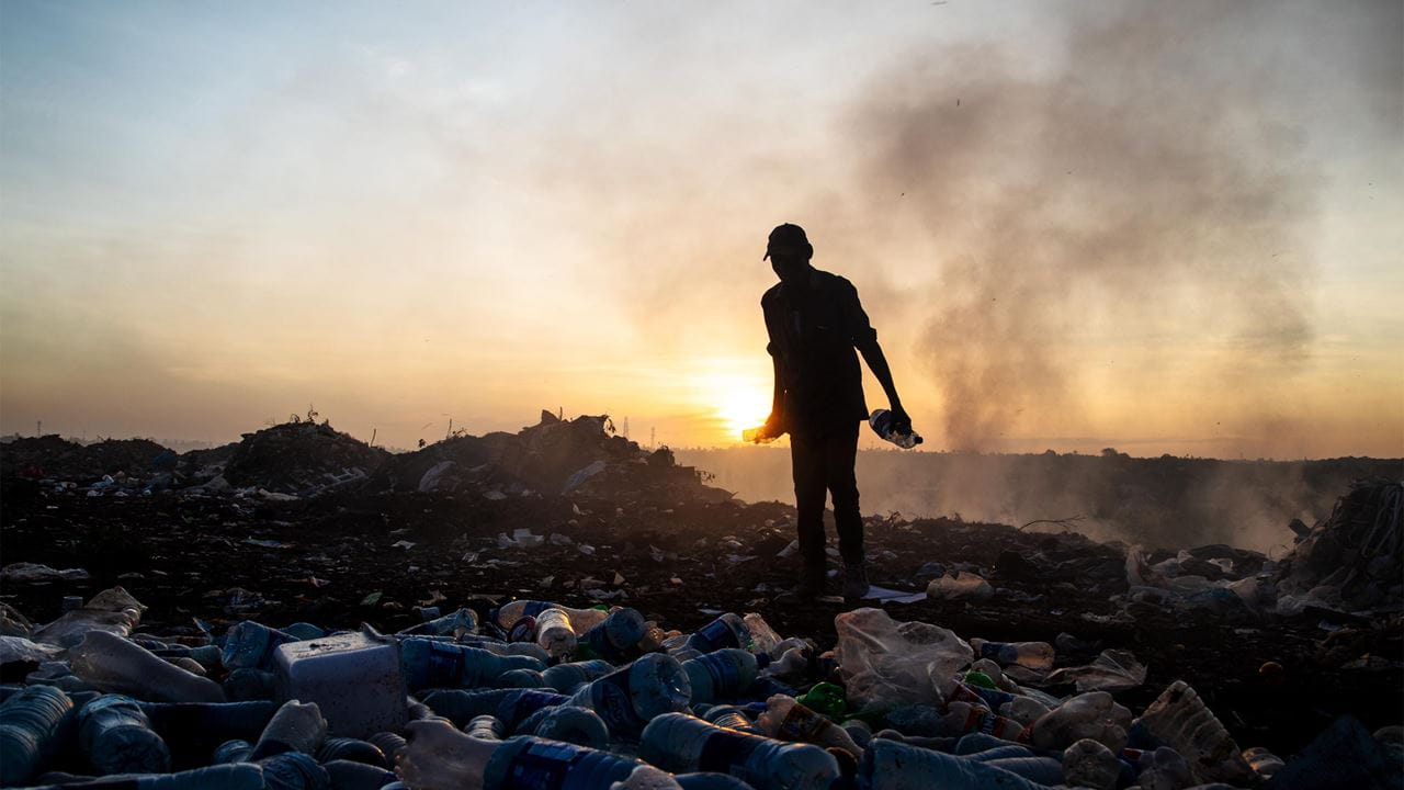 A waste picker collecting plastic bottles at a dump in Tanzania.
