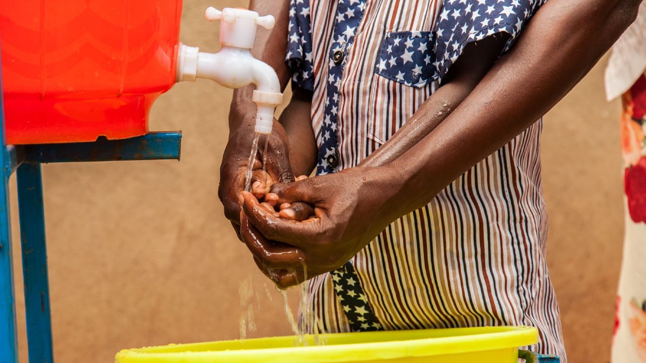 Une mère apprend à son enfant à se laver les mains dans le village de Riyakarenzi, dans l'est du Rwanda, où Tearfund travaille avec son partenaire African Evangelistic Enterprise (AEE). Photo : Chris Hoskins/Tearfund