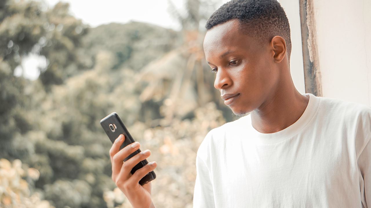 A young man looks at his mobile phone