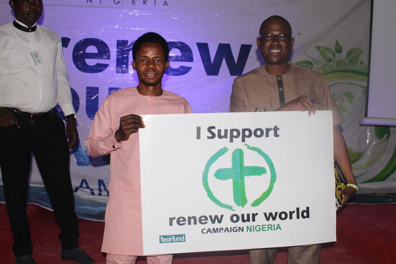 Nigerian campaigners in the city of Jos holding a placard in support of the Renew Our World movement