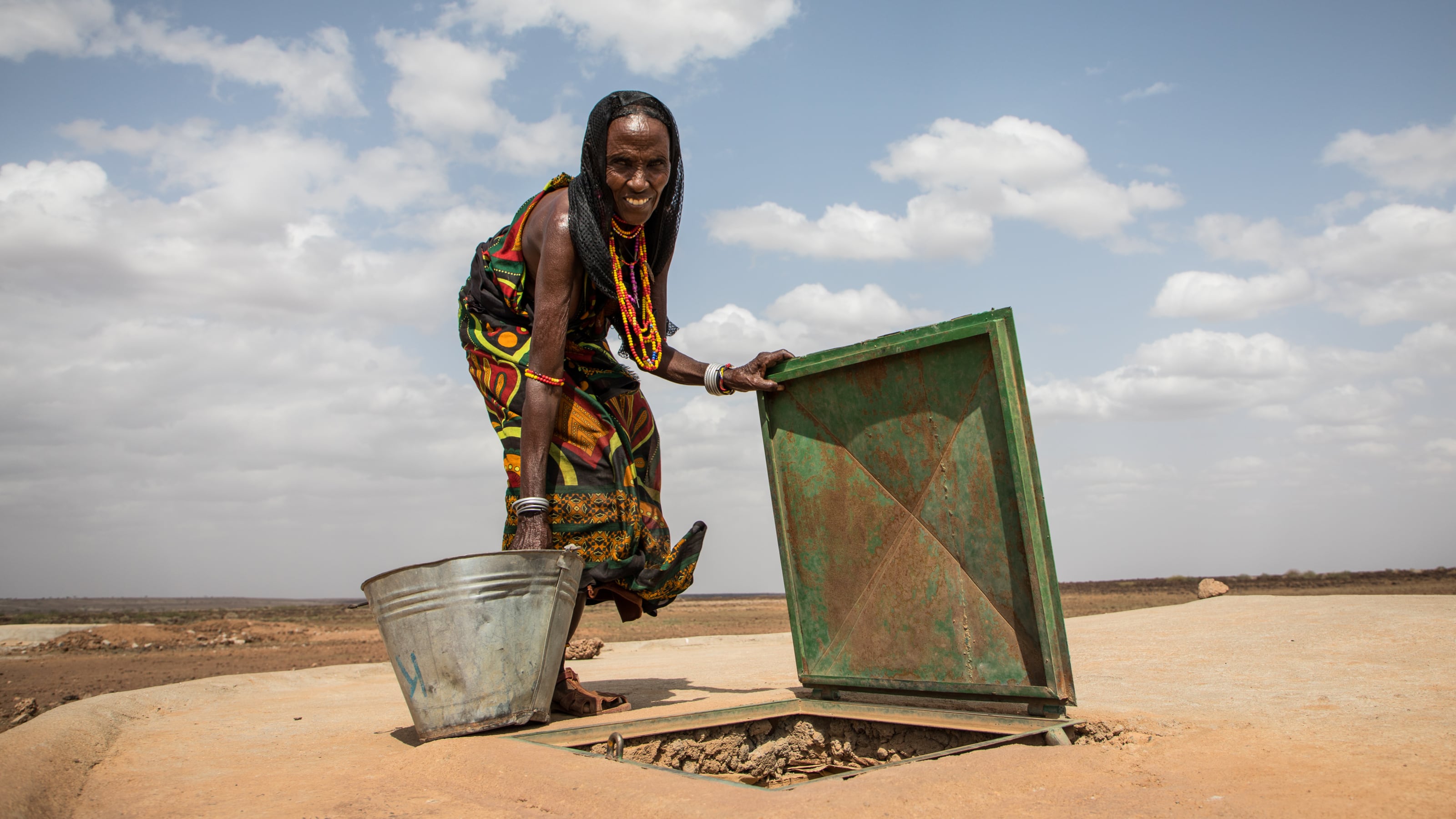 Photo of woman accessing a well.